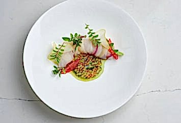 Seared scallop with delicate garnish on fine China served at Gravetye Manor restaurant in West Sussex.