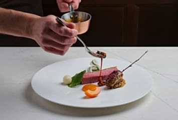 Seared duck with glazed vegetables and rich jus. Fine dining presentation at Gravetye Manor.