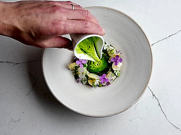 White asparagus with hollandaise and herbs on fine China. Seasonal starter at Gravetye Manor restaurant.