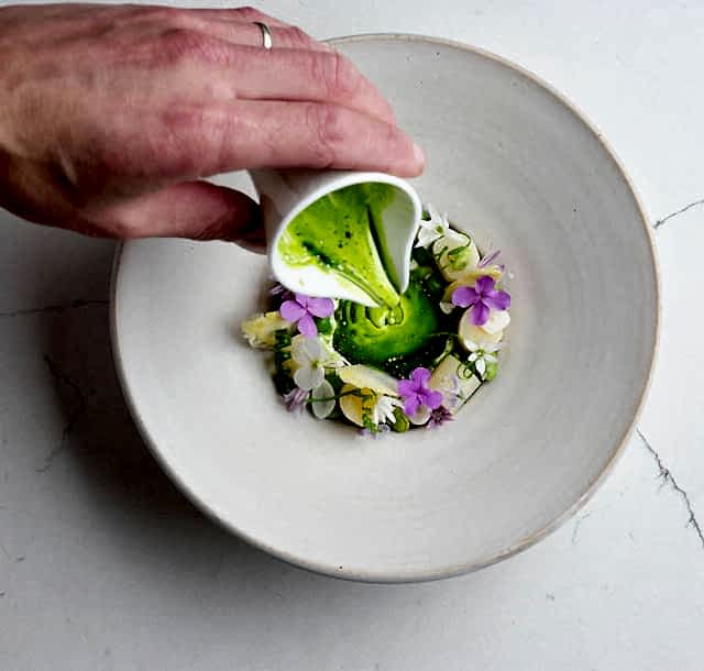 White asparagus with hollandaise and herbs on fine China. Seasonal starter at Gravetye Manor restaurant.